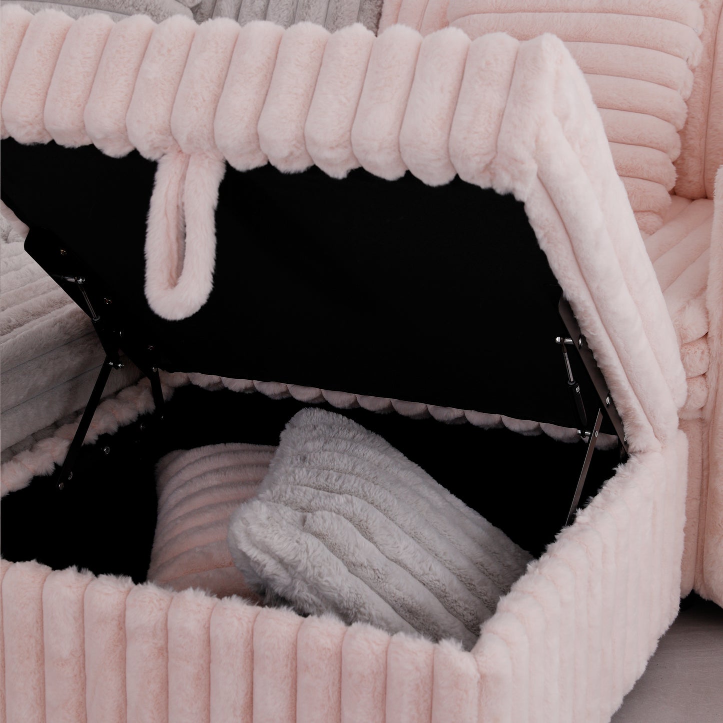 Plush pink velvet storage ottoman open to reveal black interior and two cushions