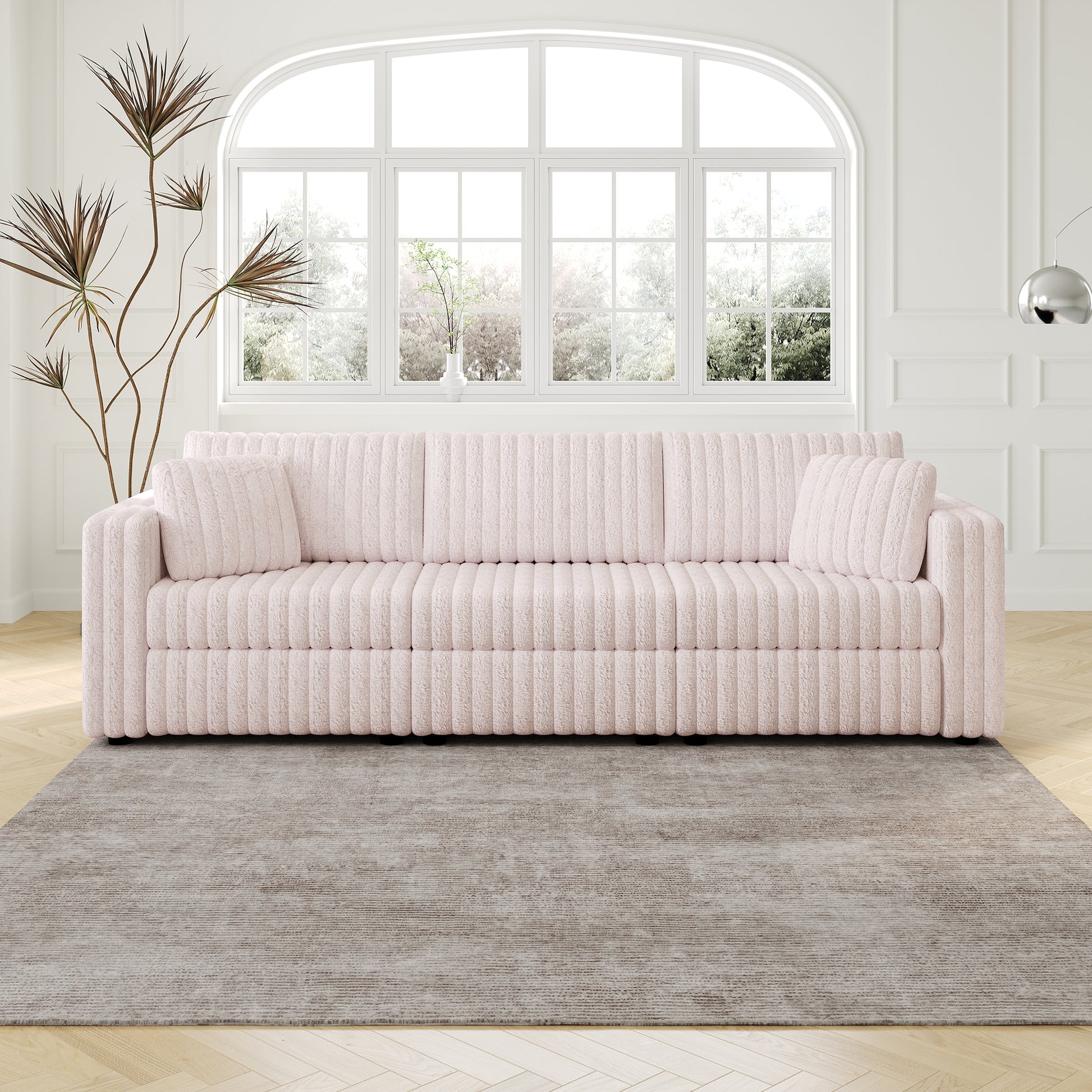 Plush pink ribbed sofa with two accent pillows and clean lines ideal for modern living rooms