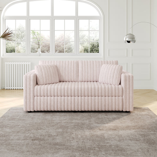 Plush pink ribbed sofa with two throw pillows in a modern living room setting