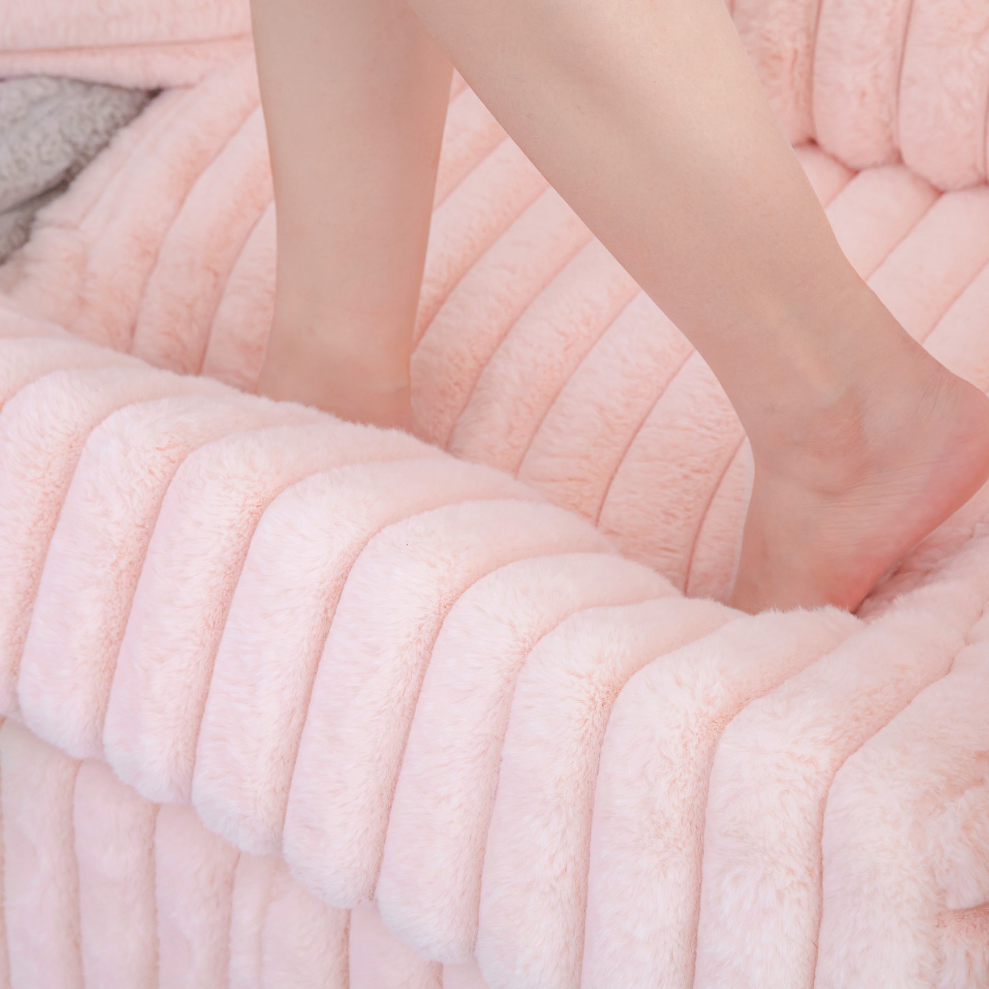 Luxurious plush pink velvet pillow with ribbed texture perfect for cozy seating