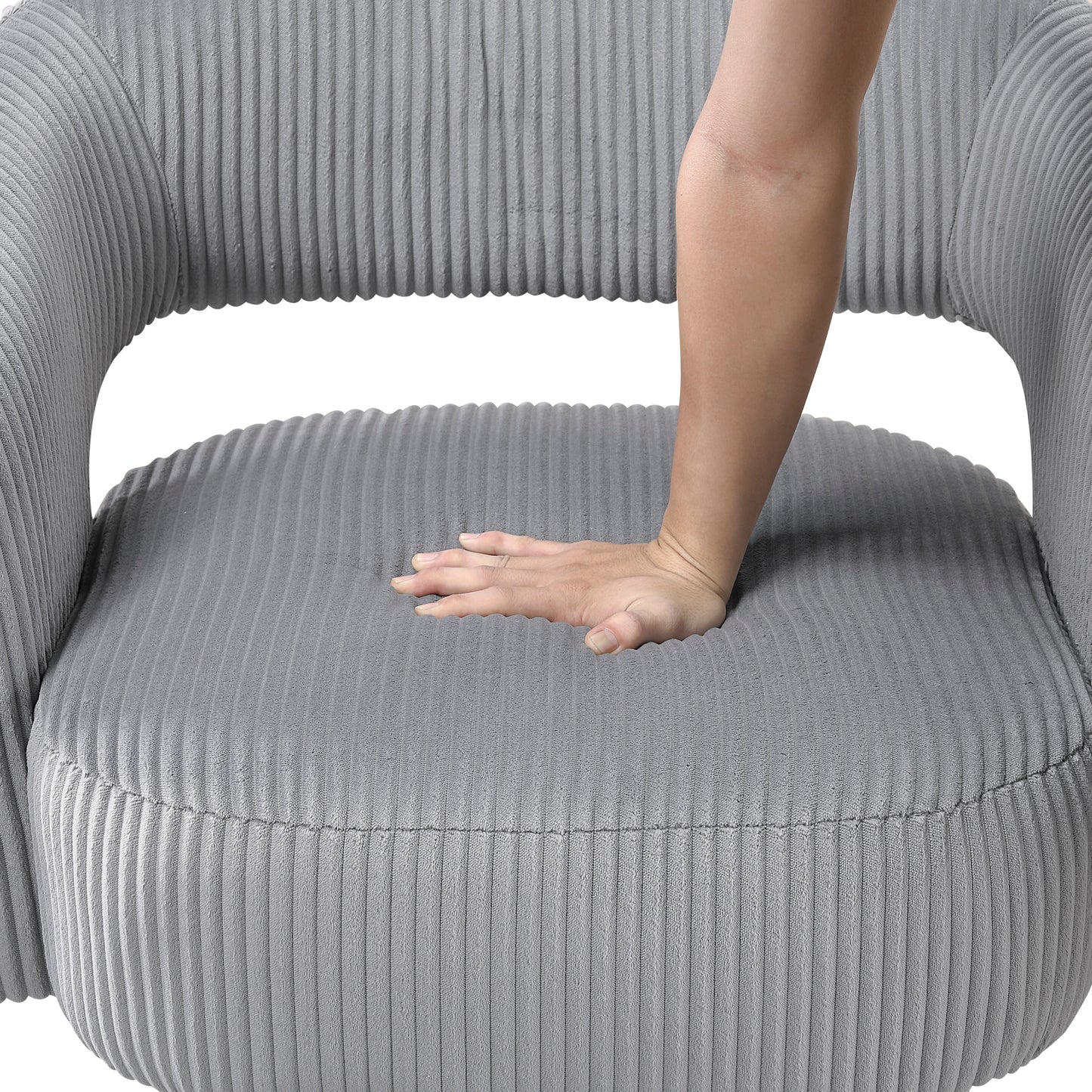 Closeup of a plush gray corduroy armchair seat showing its soft texture with a hand pressing down