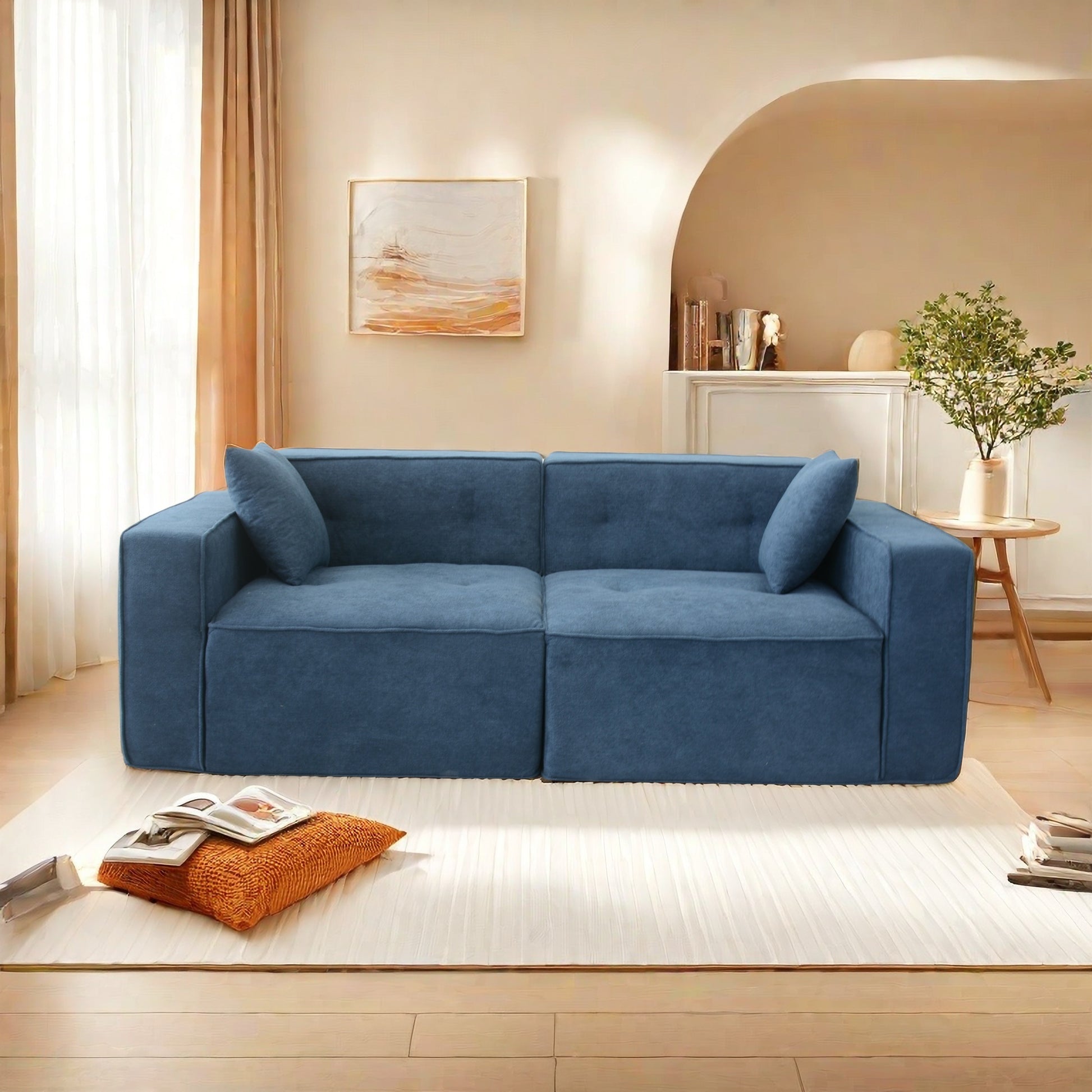Modern blue fabric sectional sofa with two toss pillows and tufted cushions