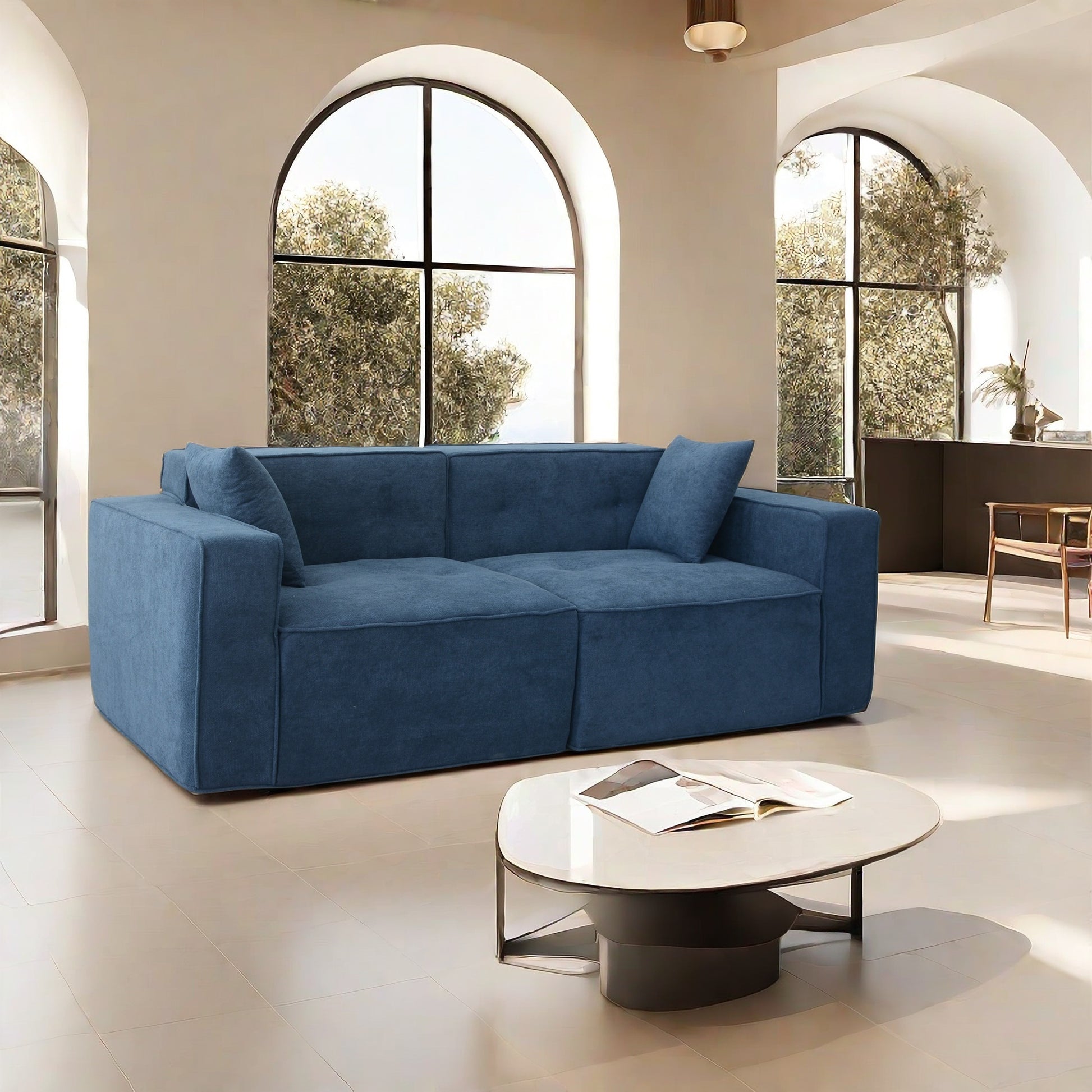 Spacious blue fabric sofa with tufted seat cushions a modern living room centerpiece
