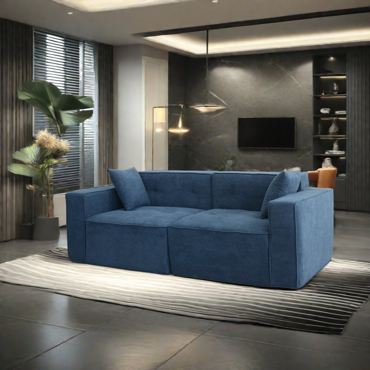 Deep blue fabric modular sofa with two accent pillows on a striped rug