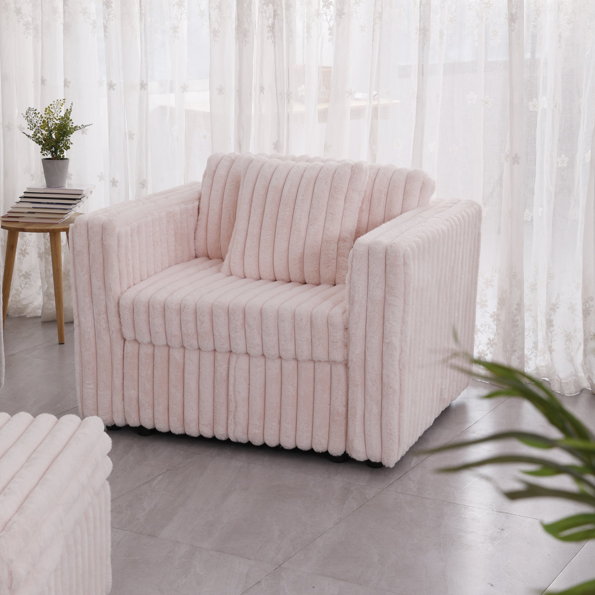 Plush pink armchair with vertical ribbed texture and matching cushion perfect for a cozy living room
