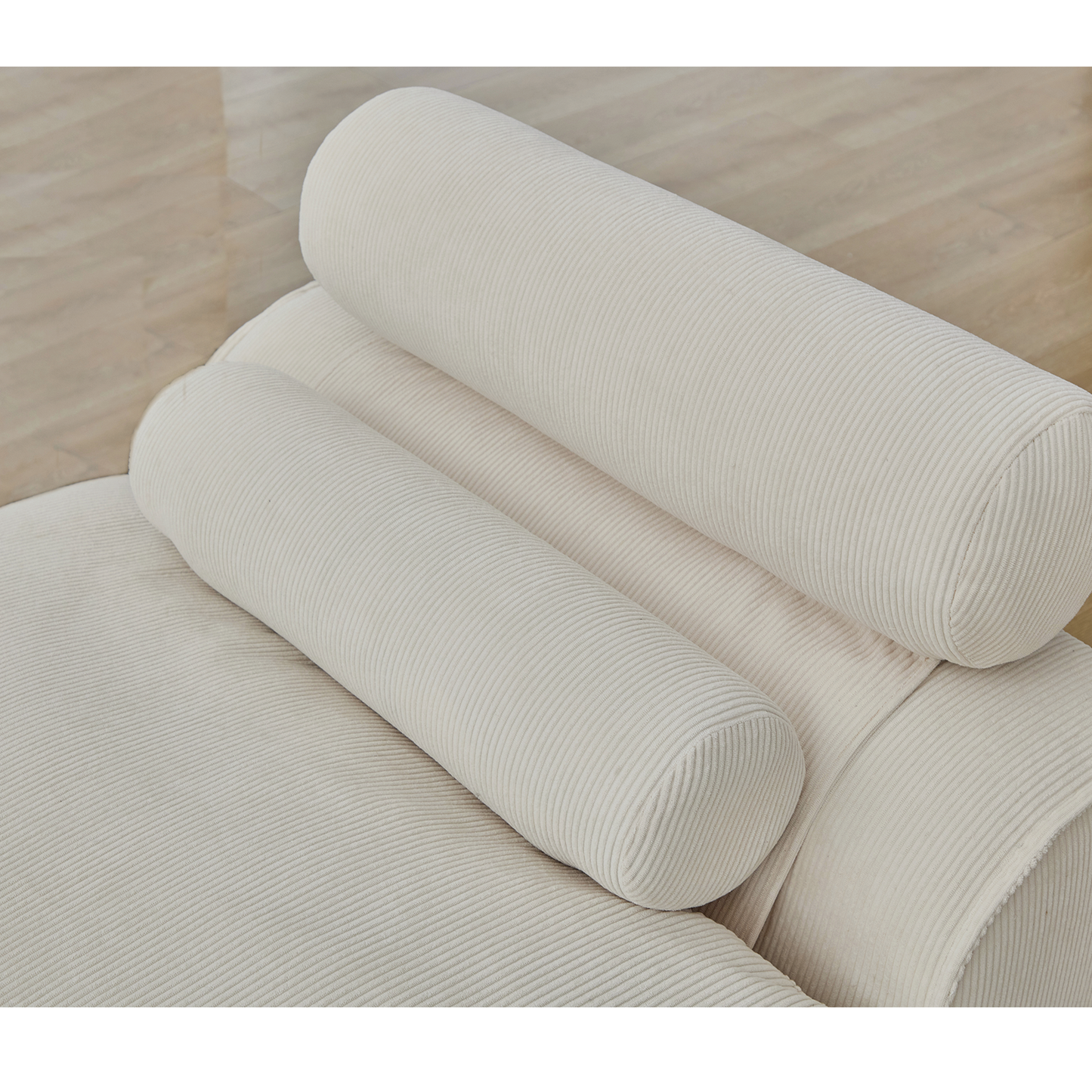 Closeup of a cream corduroy sofa with two bolster pillows for comfortable seating