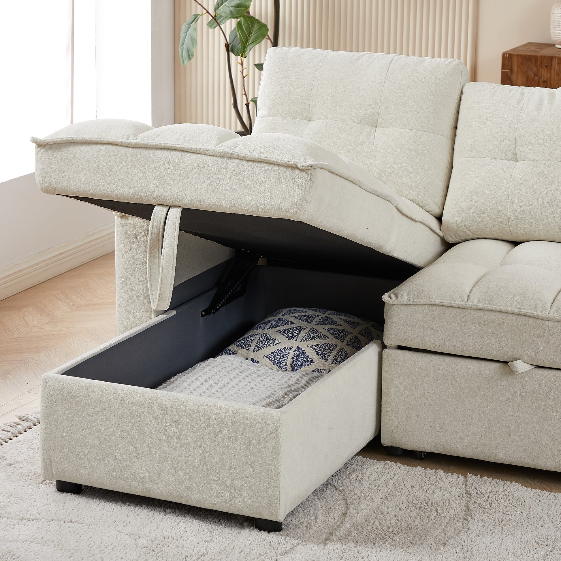 Cream sectional sofa with hidden storage compartment open revealing blankets and pillows