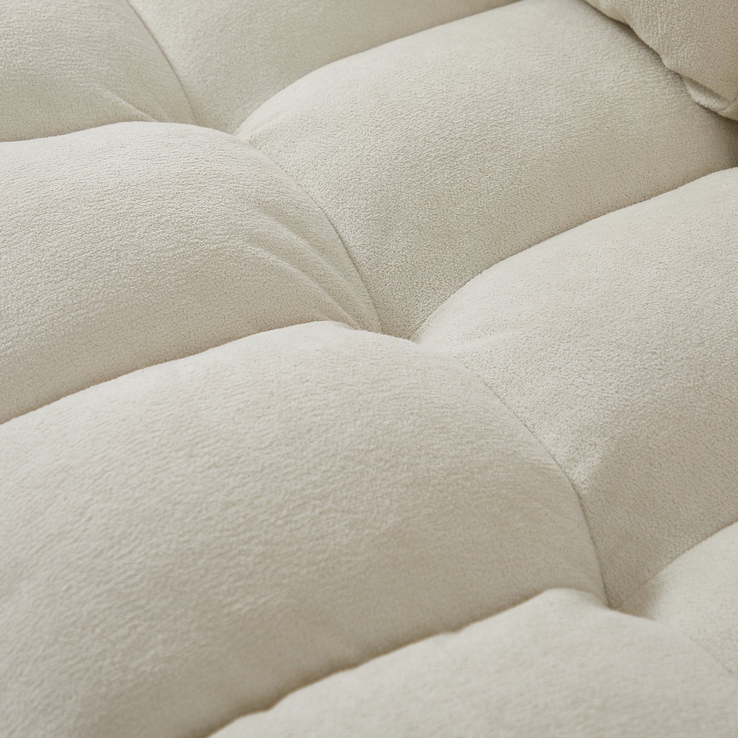 Closeup of textured cream boucle fabric showing its soft plushness and tufted design