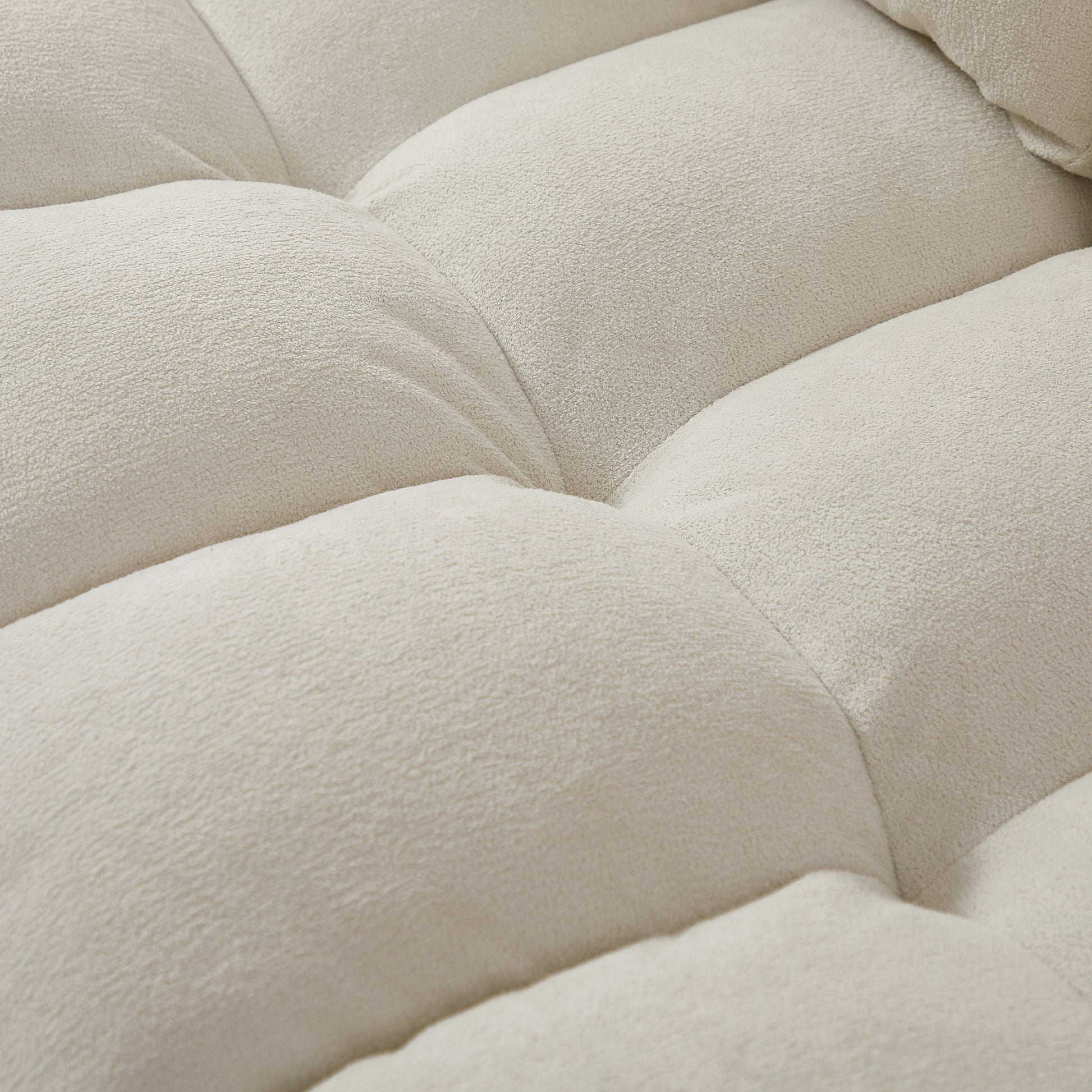 Closeup of textured cream boucle fabric showing its soft plushness and tufted design