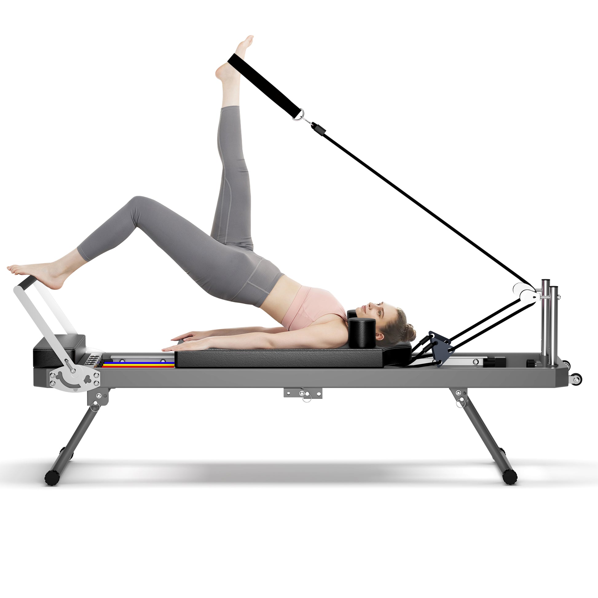 Woman performing a leg extension exercise on a grey pilates reformer machine