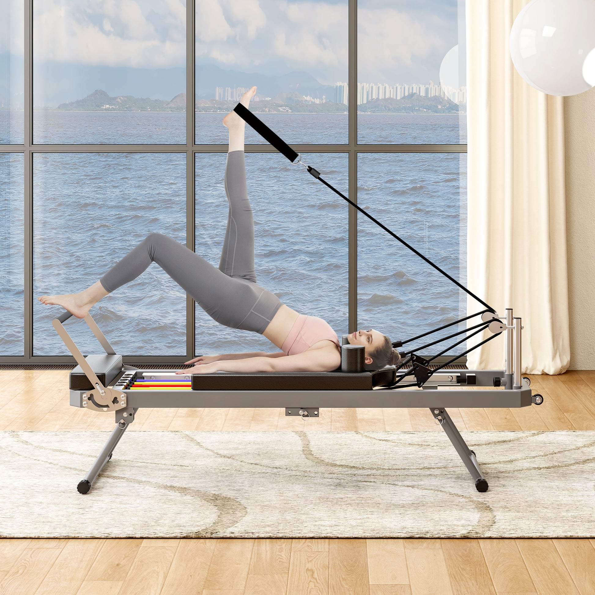 Gray Pilates reformer with a woman performing a leg exercise featuring resistance bands