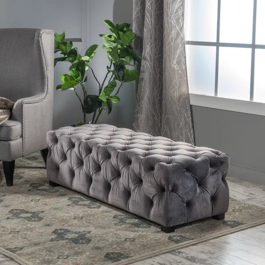 Tufted grey velvet rectangular ottoman with deep button accents complementing modern living rooms