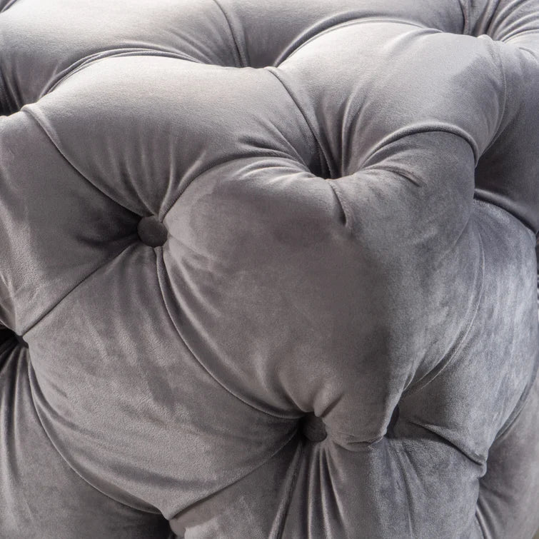 Closeup of a plush gray velvet tufted ottoman