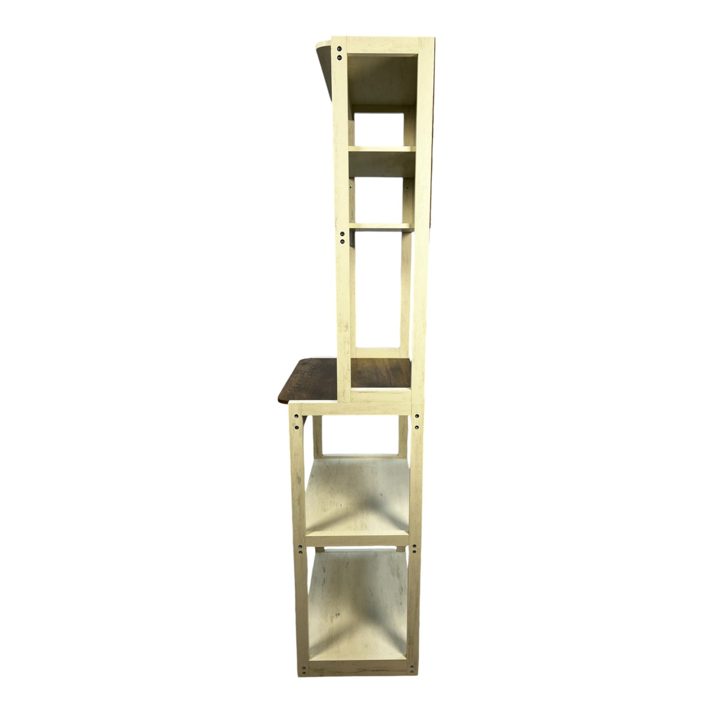 Tall creamcolored wooden bookshelf with dark wood accents featuring multiple open shelves and a midlevel desk