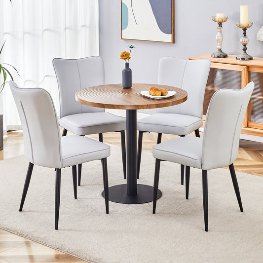 Light grey upholstered dining chairs with black legs around a round wood table