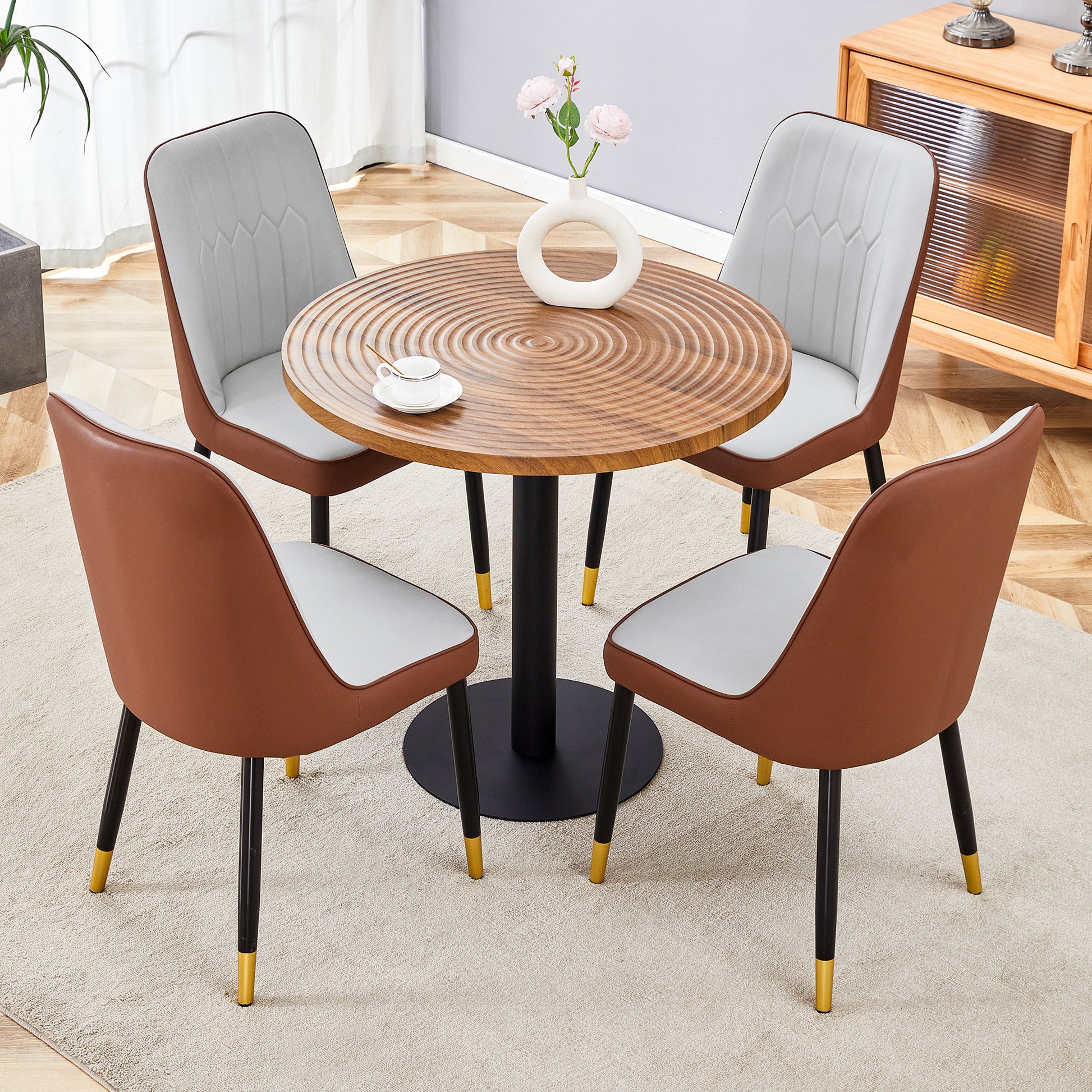 Round wood dining table with four modern chairs featuring brown and white upholstery