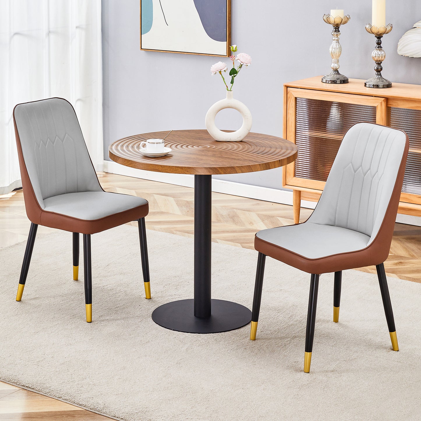 Modern accent chair with grey cushioned seat and brown vegan leather trim and gold tipped legs