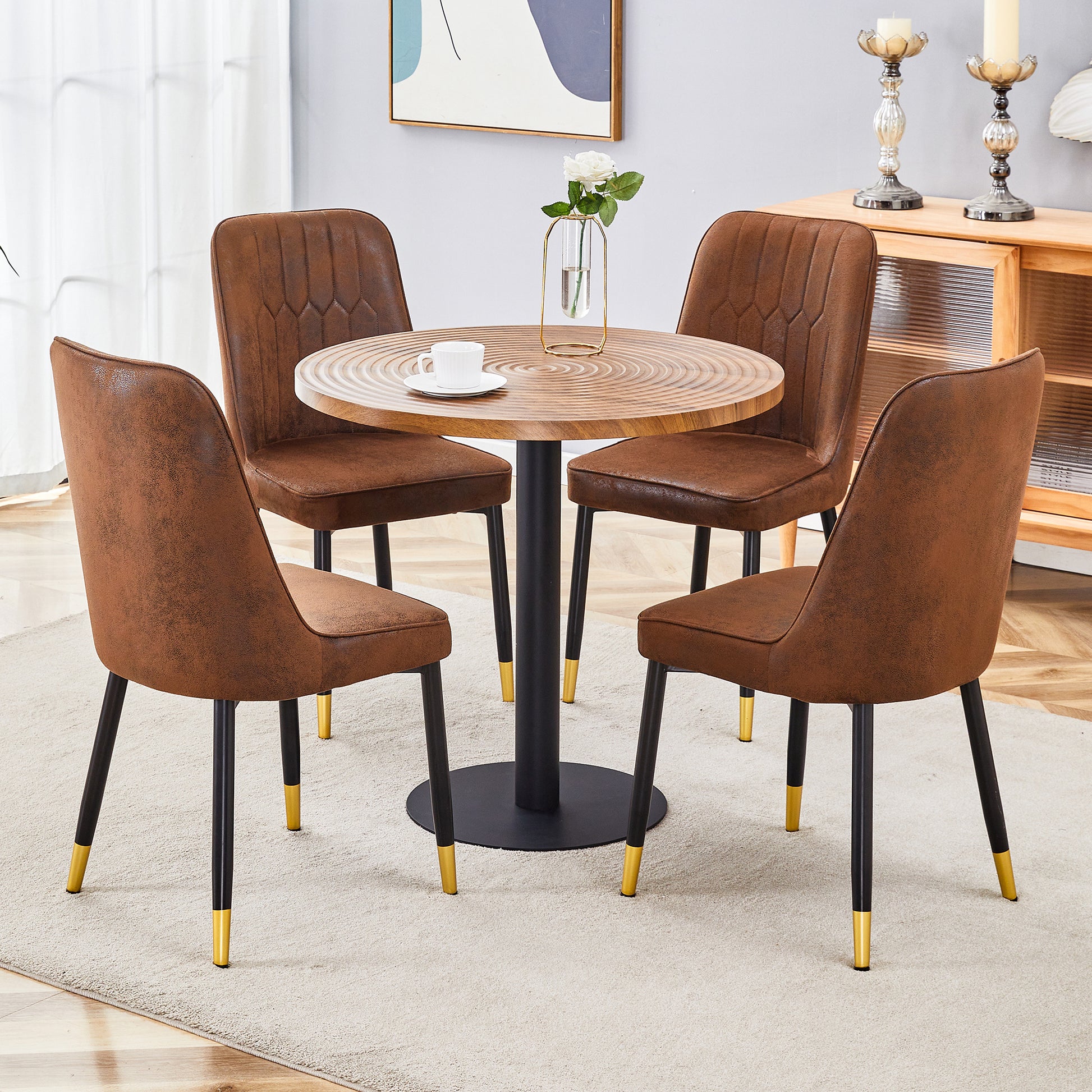 Brown suede dining chairs with tufted back and goldtipped black legs around a circular wood table