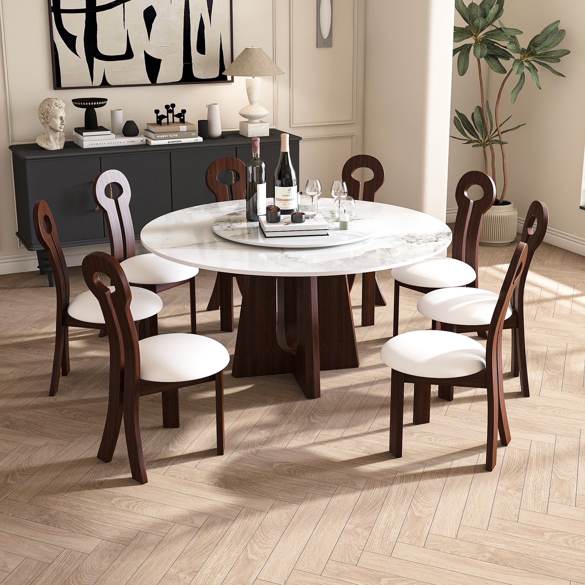 Round marble dining table with white upholstered chairs and dark wood accents
