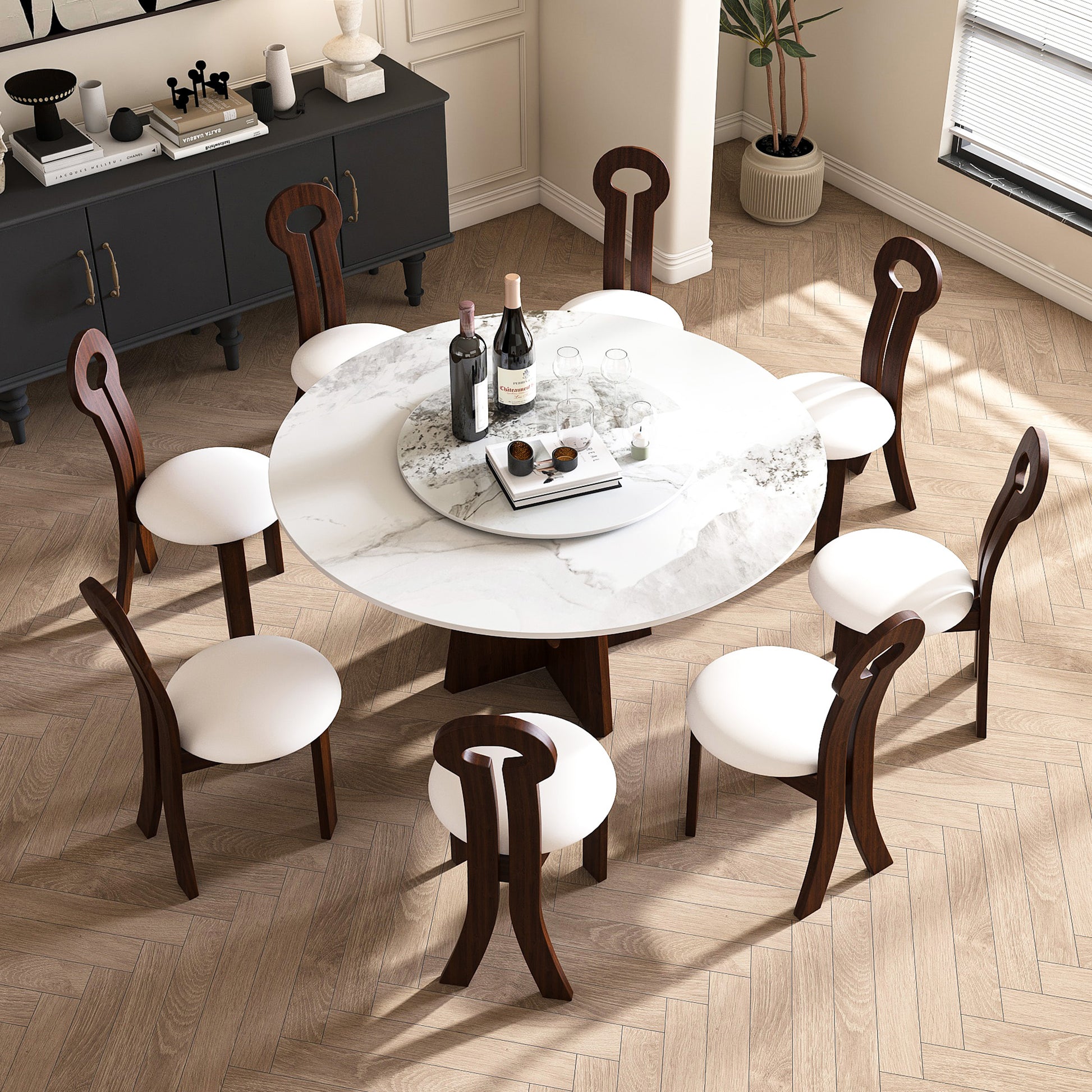 Round marble dining table with dark wood chairs and white seats set for a meal
