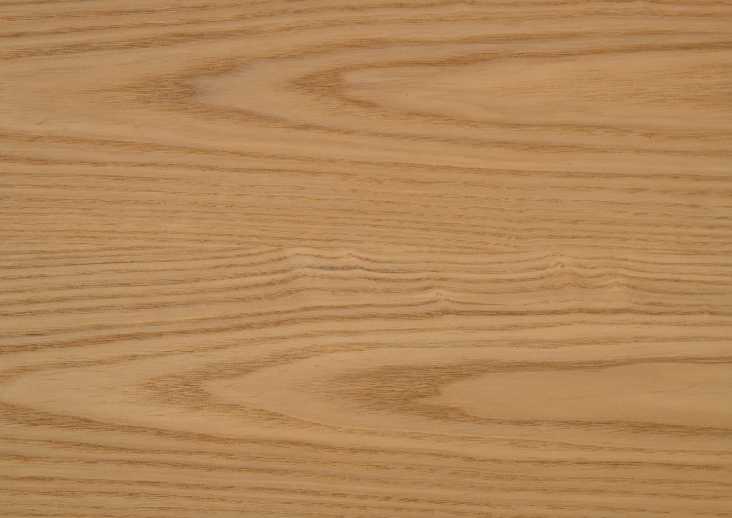 Closeup of natural ash wood grain showcasing wavy patterns and warm light brown tones