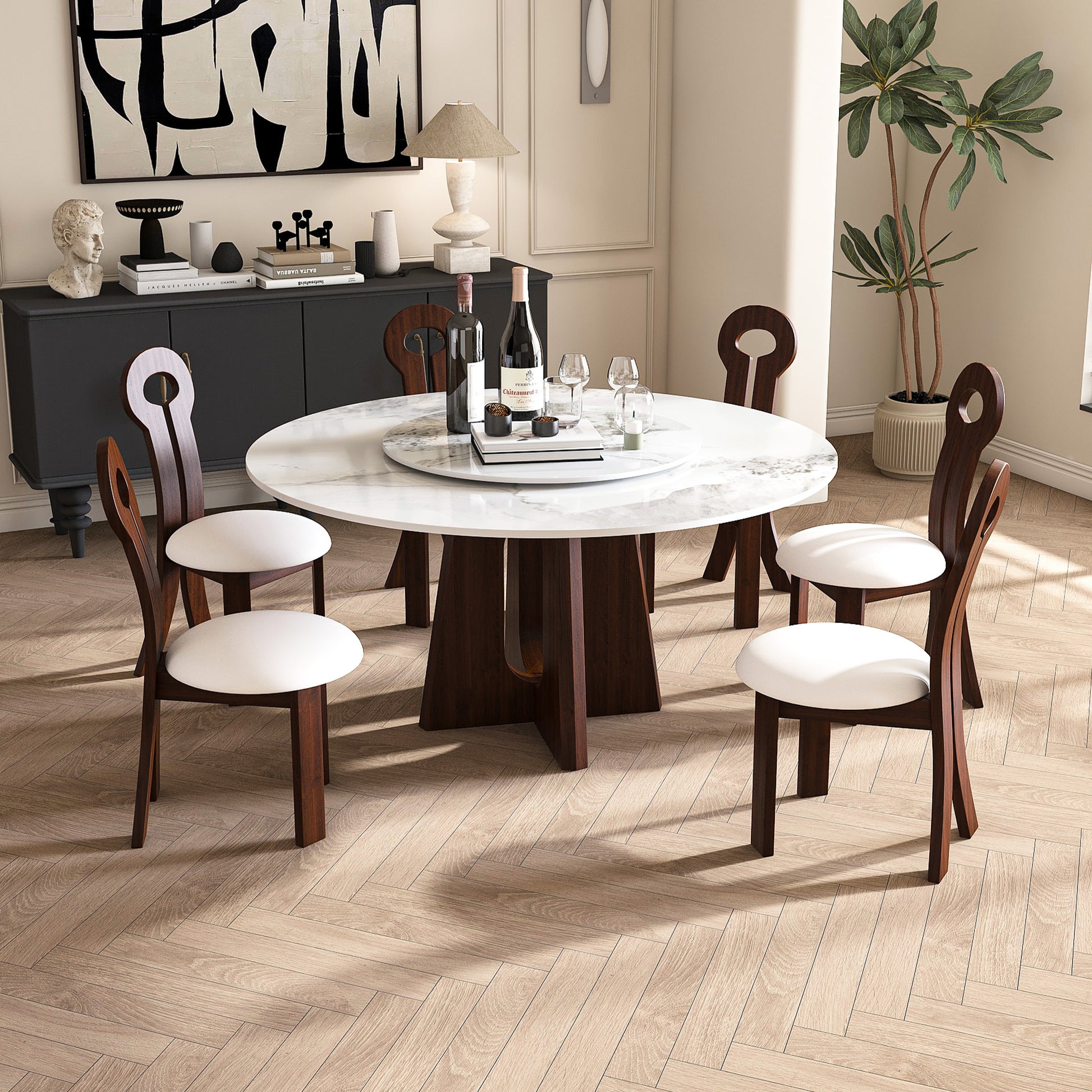 Round marble dining table with dark wood base and four white upholstered chairs