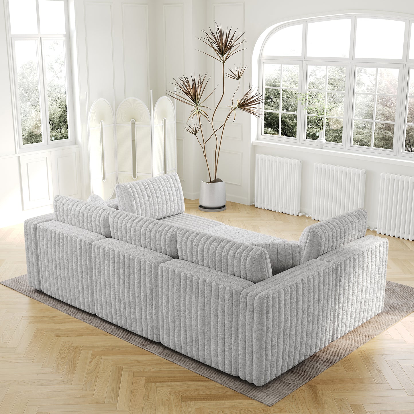 Light gray textured sofa with deep cushions and wooden floors