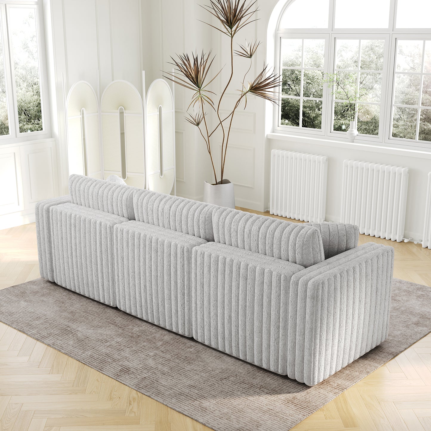Modern textured grey sectional sofa with plush upholstery on a cream rug