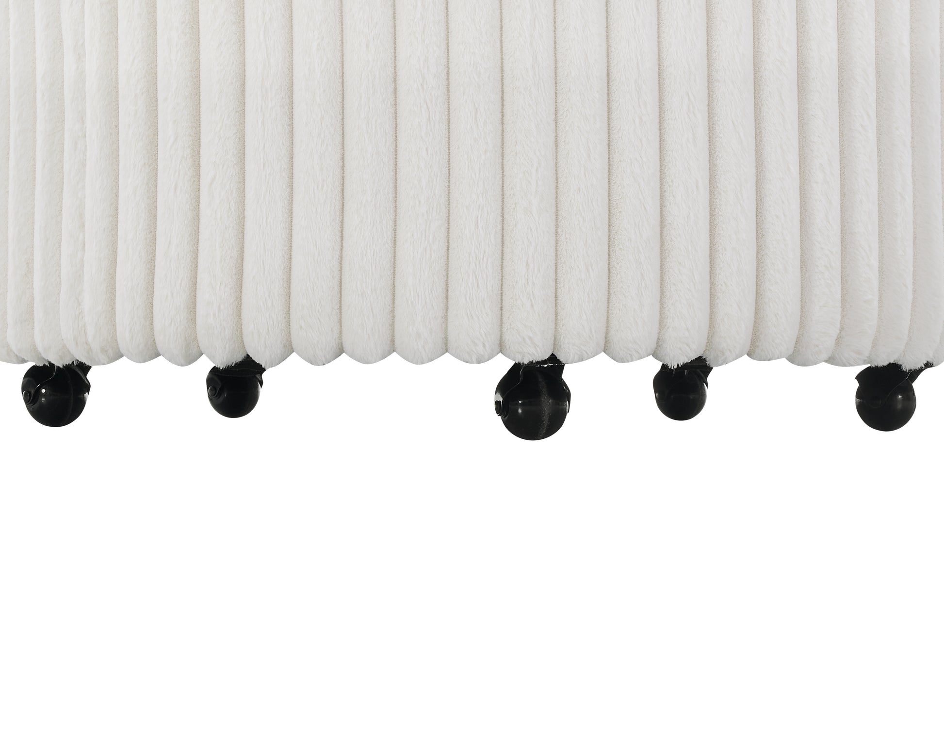 Plush white fabric ottoman with vertical ridges and black rolling casters