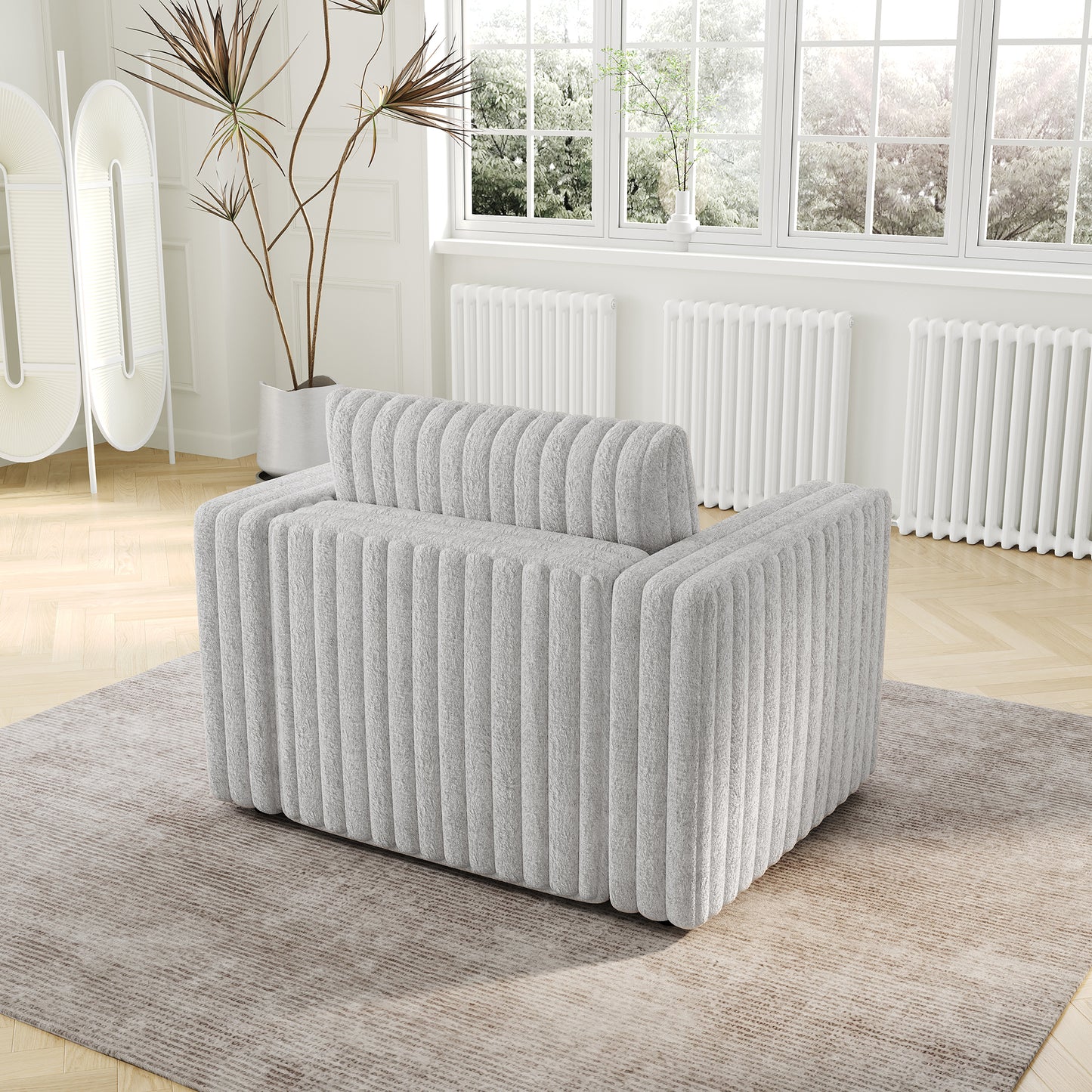 Modern plush armchair in light gray with vertical channel tufting