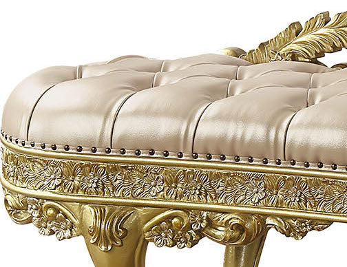 Tufted beige leather ottoman with ornate gold carved trim