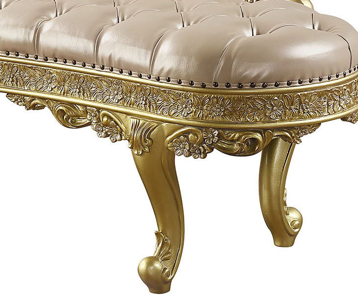 Tufted beige leather bench with ornate gold carved legs and trim