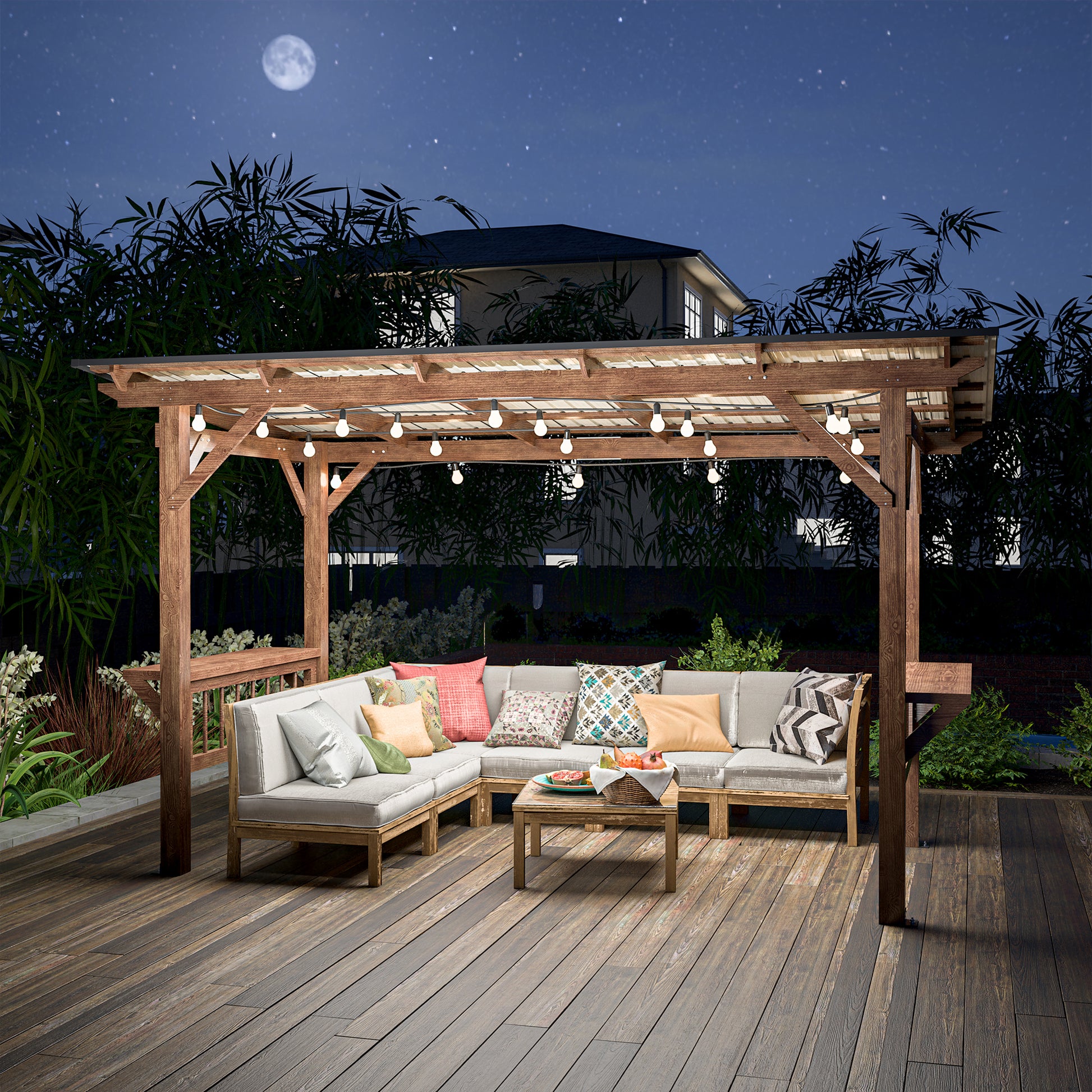 Modern sectional patio furniture with decorative pillows under a wooden pergola at night