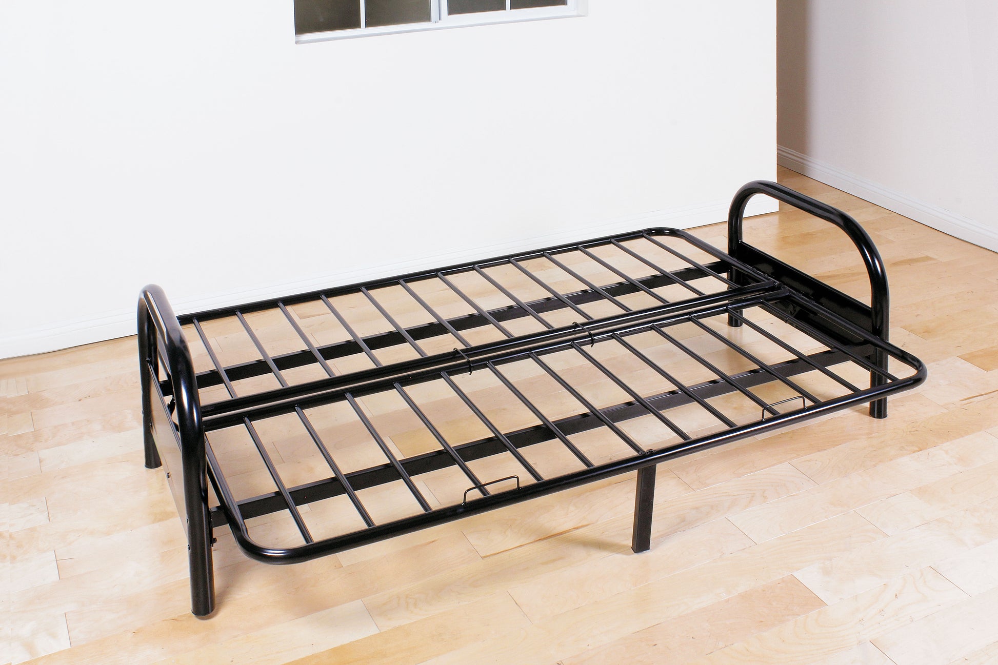 Black metal twin folding bed frame with a slatted surface ideal for guest rooms