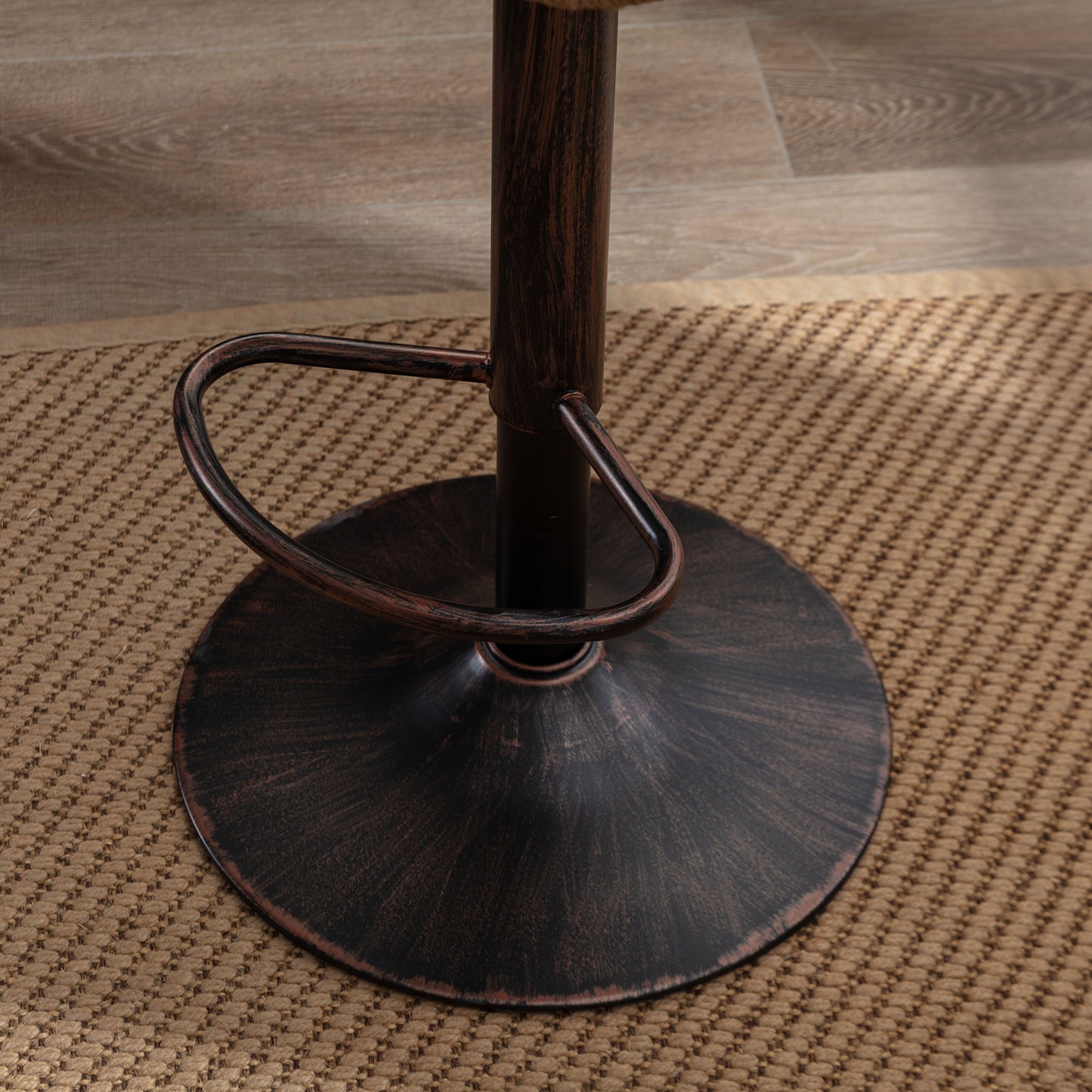 Bronzefinished adjustable bar stool base with footrest on woven rug