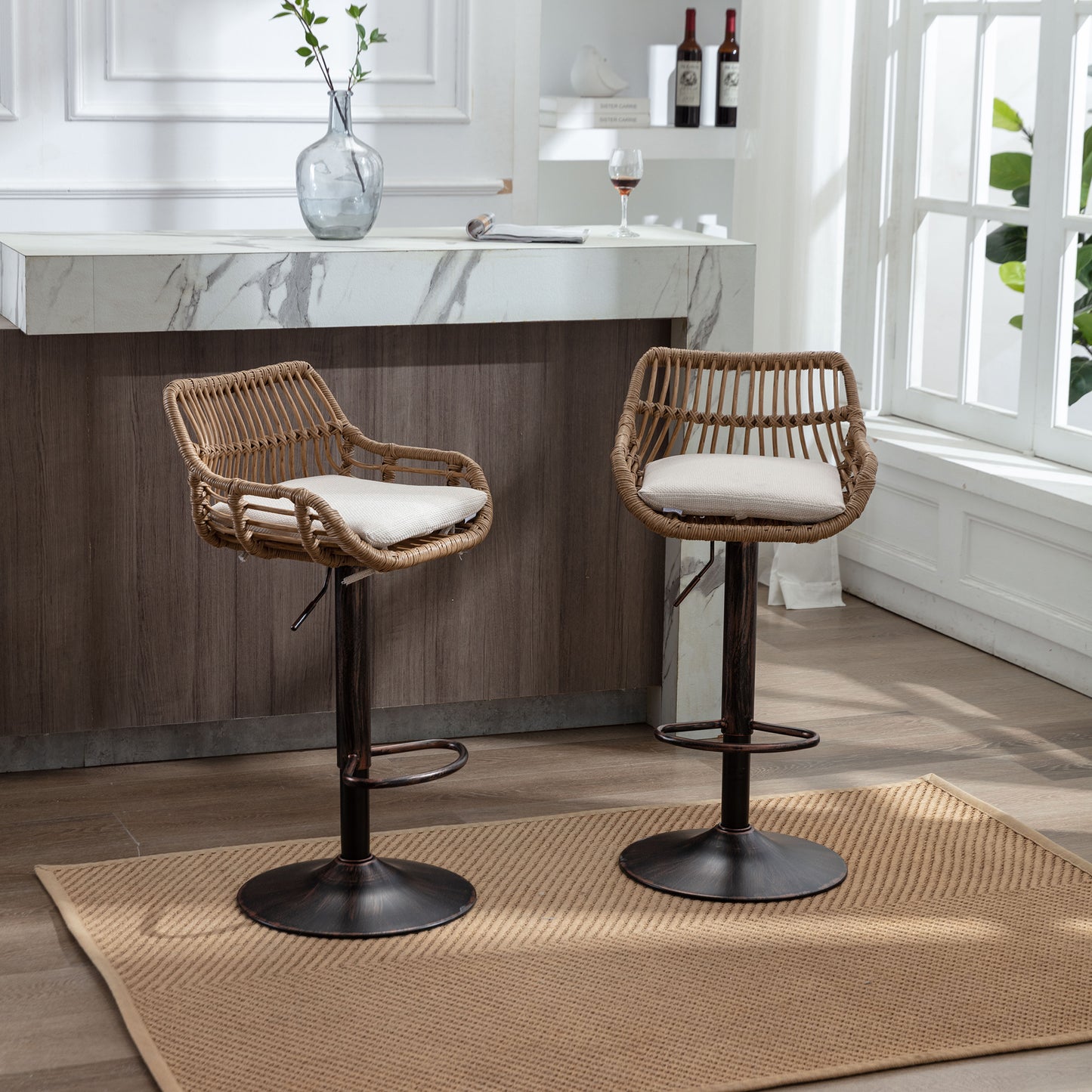 Two brown rattan bar stools with cream cushions and bronze bases sit on a tan rug