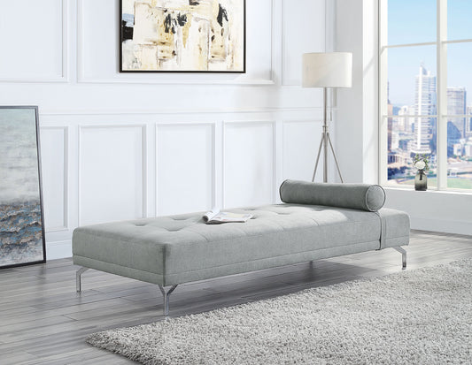 Tufted grey fabric chaise lounge with cylindrical bolster pillow and chrome legs