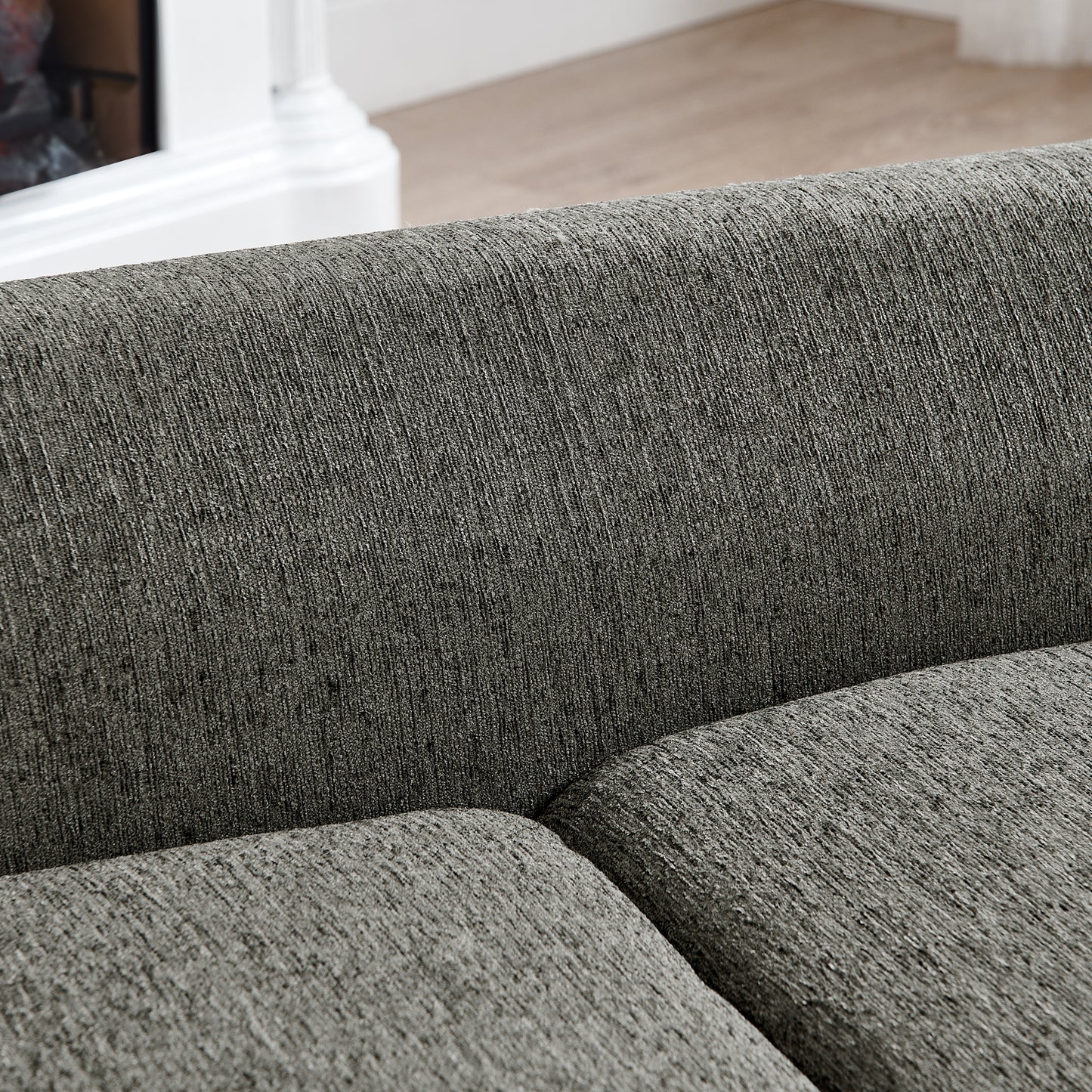Closeup texture of charcoal grey woven fabric on a modern sofa cushion