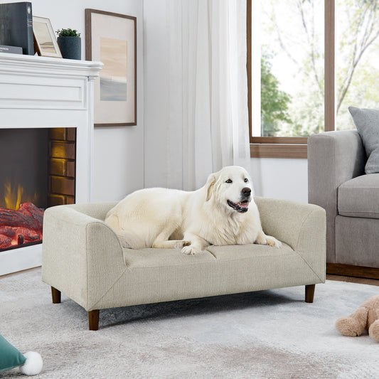 Beige upholstered dog bed with raised sides and wooden legs featuring a large white dog resting comfortably