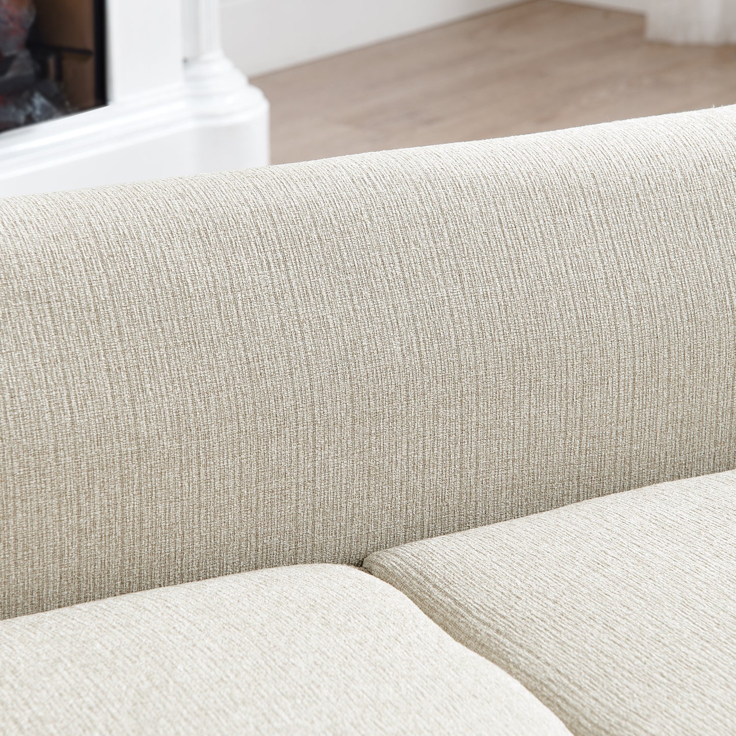 Closeup of a textured beige sofa cushion showing its woven fabric detail