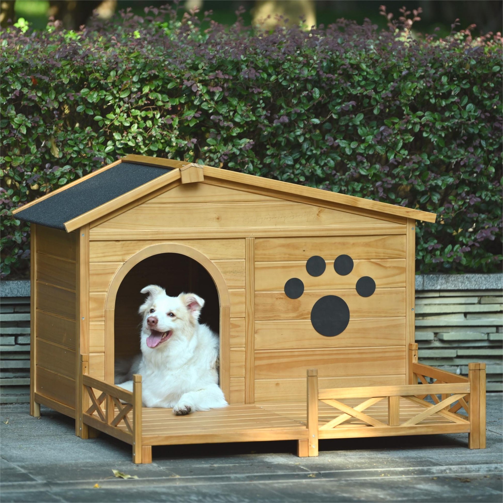 Wooden dog house with porch and a happy dog lounging inside