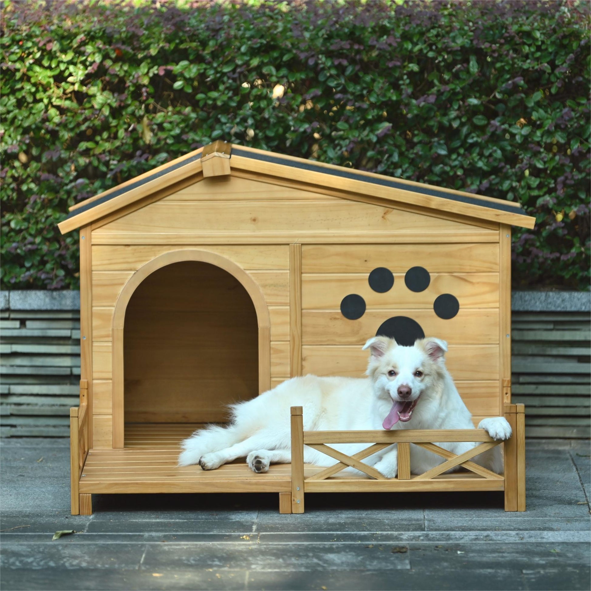 Natural wood dog house with an attached porch and a happy dog relaxing
