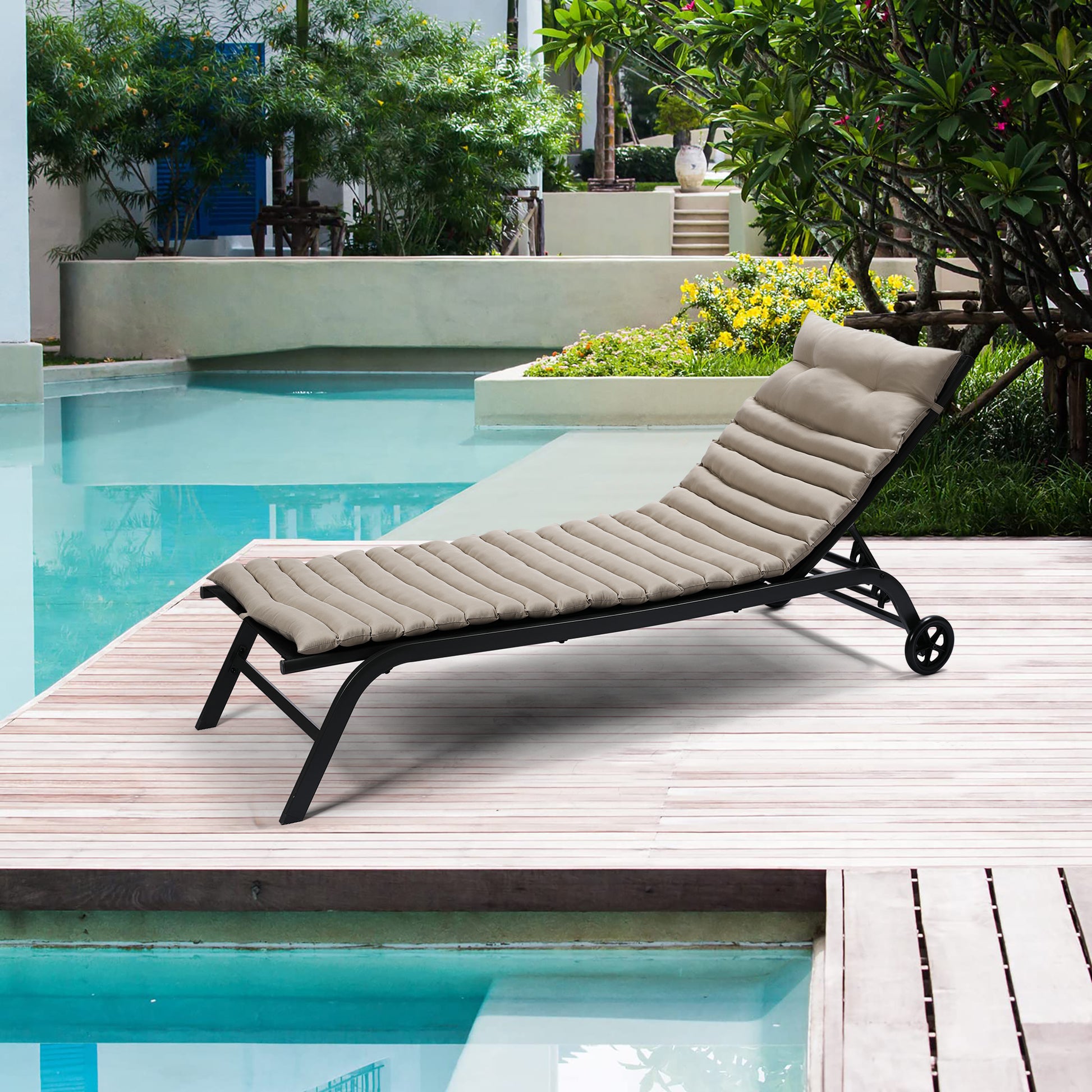 Tan padded adjustable chaise lounge chair with black frame on wooden deck