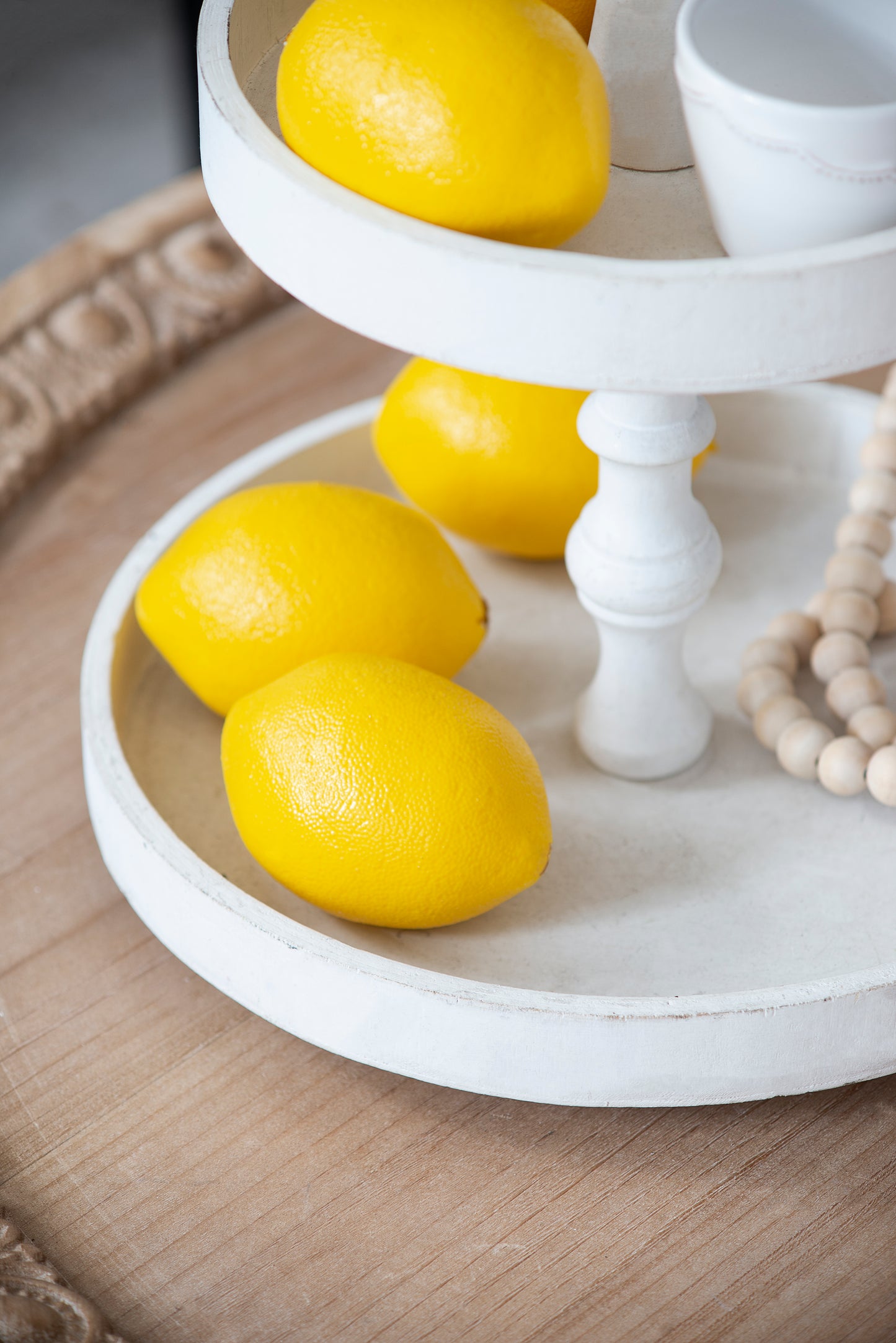 Bright yellow lemons arranged on a rustic white tiered stand