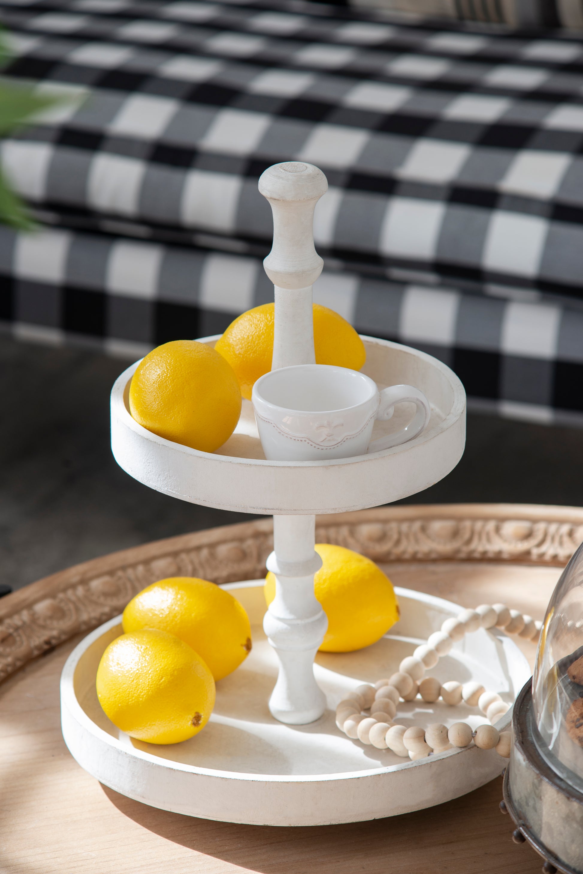 White wooden tiered tray with fresh lemons and a teacup