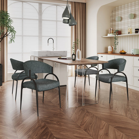Four dark grey upholstered dining chairs with black metal frames arranged around a modern dining table