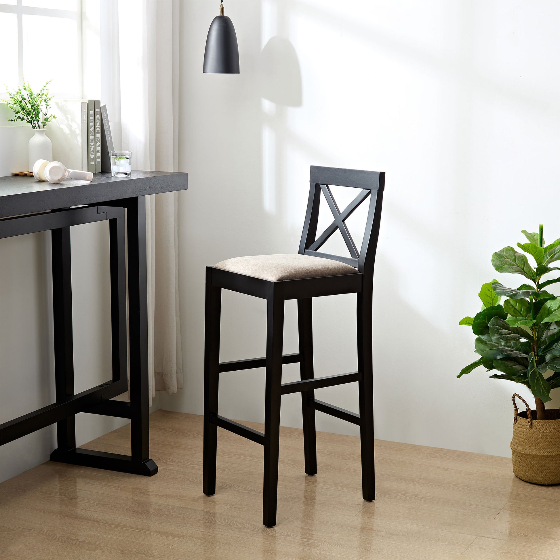 Black wooden bar stool with a beige upholstered seat and Xback detail
