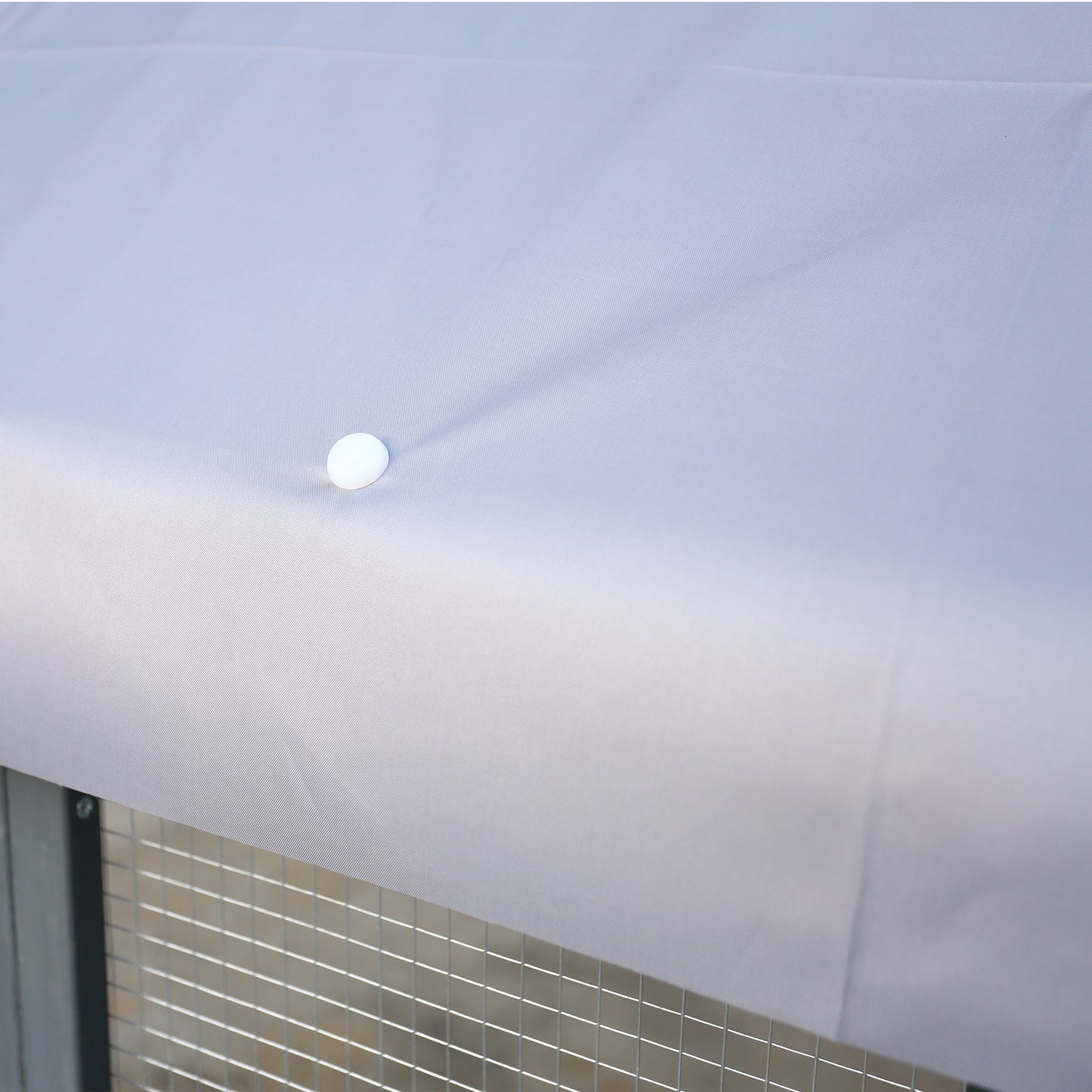 Light grey waterproof cover for outdoor pet enclosure secures with fasteners