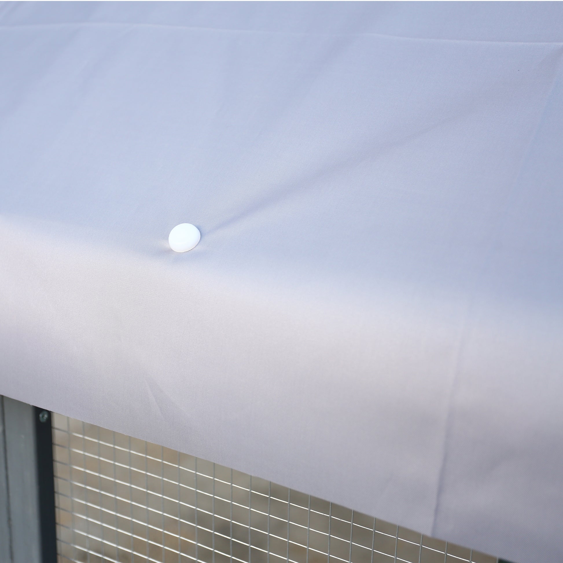 Light grey waterproof cover for outdoor pet enclosure secures with fasteners