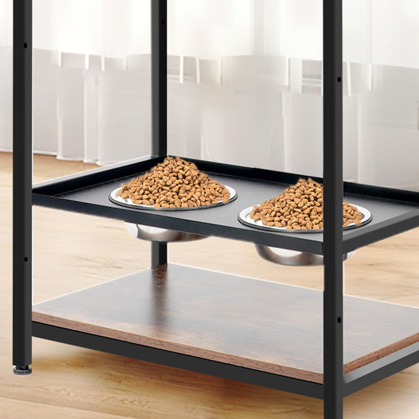 Black metal elevated dog feeder stand with two stainless steel bowls filled with kibble